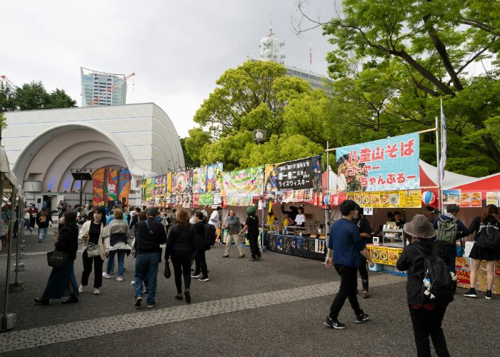 Visitors to the Okinawa Festival, walking past food and drinks stalls at Yoyogi Park.